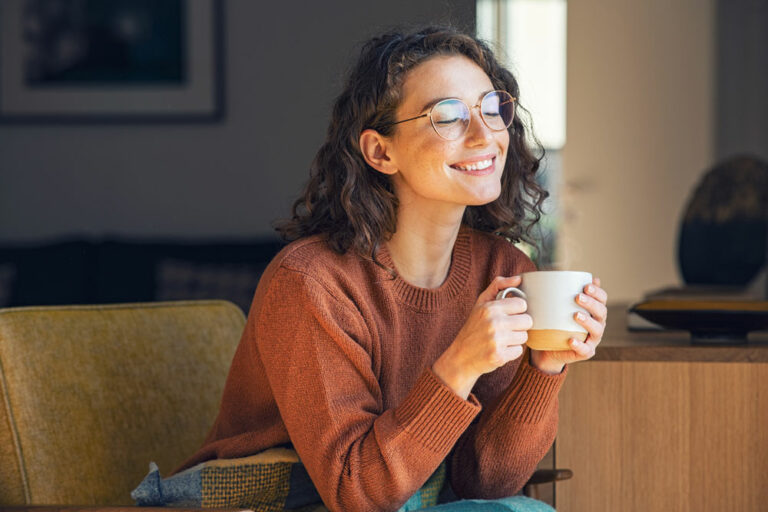girl smiling and holding a coffee cup