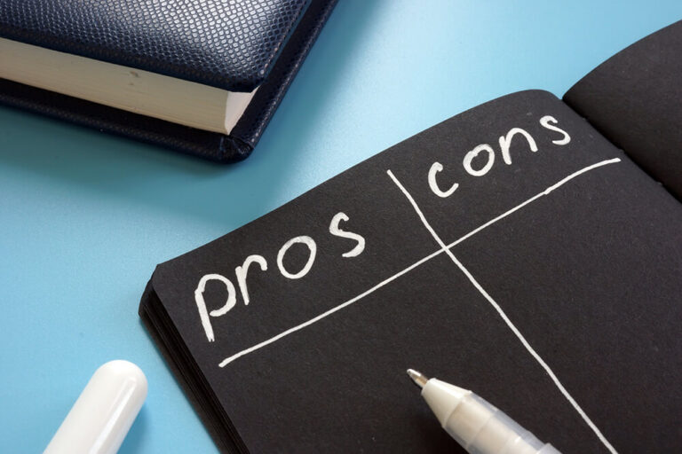 The image shows an open notebook with a black page, divided into two columns labeled "pros" and "cons" written in white ink.